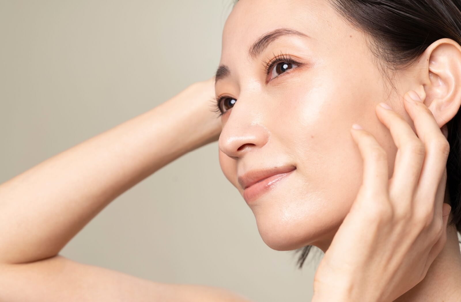 Gemini said A person with smooth, healthy skin smiling and touching their face, showcasing the benefits of specialized treatments for dry eye relief and eye comfort.